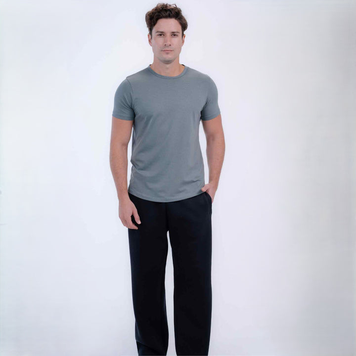 A man modeling a short-sleeve crewneck t-shirt in heather gray, paired with black pants, standing against a plain white studio background.
#color_black
