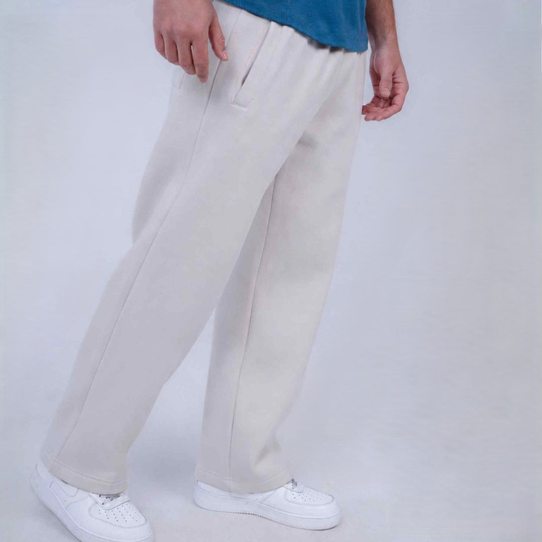 A person wearing off-white wide-leg sweatpants and white sneakers, cropped from the waist down, standing against a light gray studio background.
#color_cloud-dancer